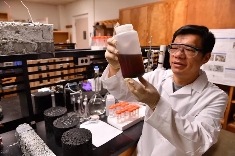 Washington State University professor Xianming Shi examines an experimental compound as part of his research into finding alternatives to road salt for ice melting on highways. He says a brining formula using a grape extract would be gentler to roads than plain old salt.