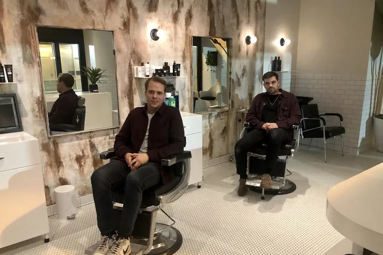 Adam Kirschenbaum (left) and Jeff Laub, two of the founders, in Blind Barber's salon. One of its bars is at the rear, behind a door.