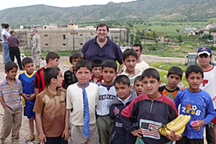 Stephen DeAngelis, of Enterra Solutions, L.L.C., with a group of Kurdish children in Iraq.