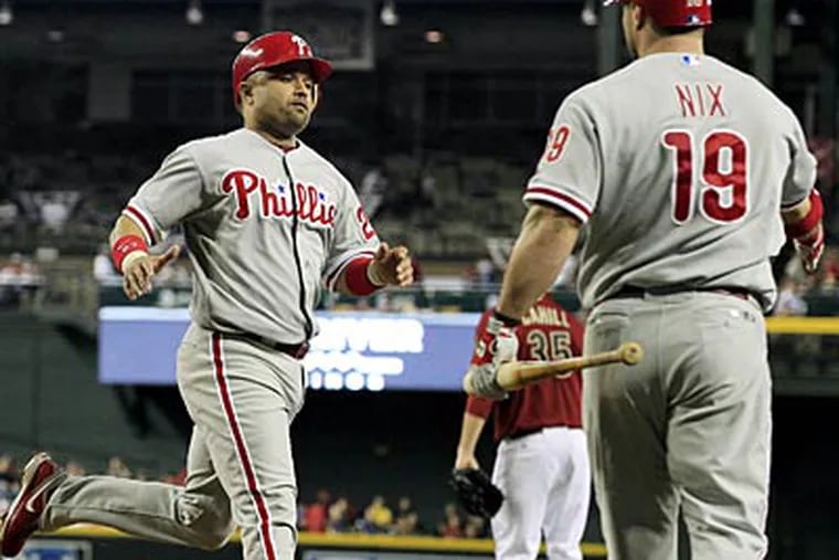 Placido Polanco celebrates with Laynce Nix after scoring in the first inning on Wednesday. (Ross D. Franklin/AP)
