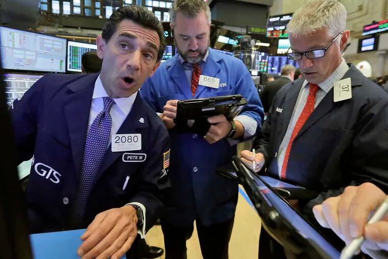 New York Stock Exchange specialist Peter Mazza (left) works with Kevin Lodewick (center) and Mark Zifchak.