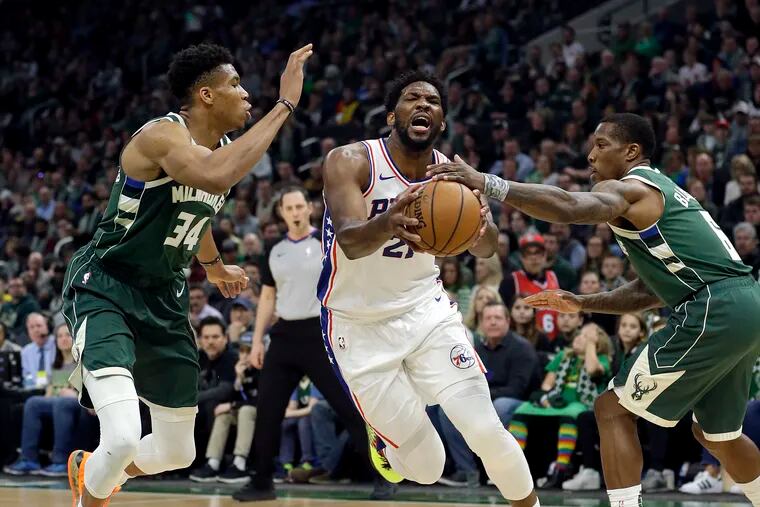 Joel Embiid tries get past the Bucks' Giannis Antetokounmpo (left) and Eric Bledsoe.