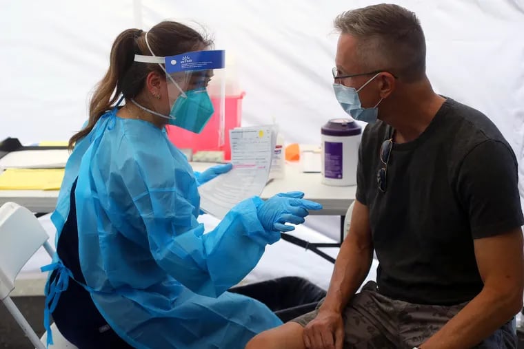 Pharmacist Michelle Huynh (left) prepares to deliver a monkeypox vaccine shot to Eric Tooley on July 20 in San Jose, Calif.