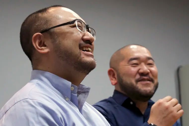 In this Jan. 28, 2019, photo, Kenji Aiba (left) and his partner, Ken Kozumi, laugh during an interview with the Associated Press in Tokyo. Kozumi and Aiba have held onto a marriage certificate they signed at their wedding party in 2013, anticipating that Japan would emulate other advanced nations and legalize same-sex unions. That day has yet to come, and legally they are just friends even though they've lived as a married couple for more than five years. On Thursday, Feb. 14, 2019, Valentine’s Day, the couple is joining a dozen other same-sex couples in Japan’s first lawsuits challenging the constitutionality of the country’s rejection of same-sex marriage.