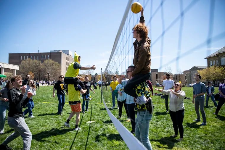 Francesco Protasi, 20, of West Chester, Pa., Sophomore, spikes the ball with the help of his fraternity brother, Evan Gartner, 30 of South River, N.J., Junior, during a volleyball game at West Chester University during Banana Day in West Chester, Pa., on Wednesday, April 20, 2022.