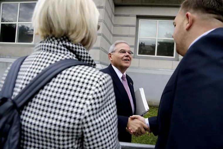 U.S. Sen. Bob Menendez, center, talks to supporters while arriving at the Martin Luther King, Jr., Federal Courthouse for his federal corruption trial, Thursday, Oct. 26 in Newark, N.J. (AP Photo/Julio Cortez)