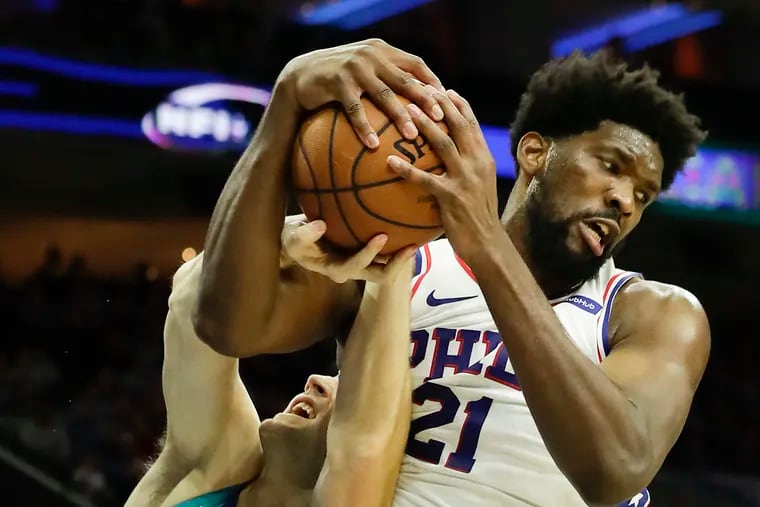 Sixers center Joel Embiid fights for the ball iwth Charlotte center Cody Zeller. Embiid, in just under 26 minutes of action, finished with 18 points and nine rebounds.