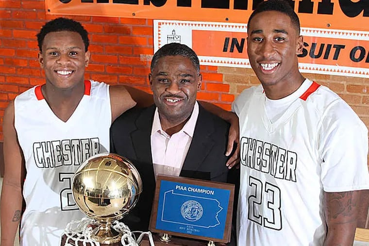 Coach Larry Yarbray holds the 2012 state championship trophy, flanked by Darius Robinson (left) and Rondae Jefferson.