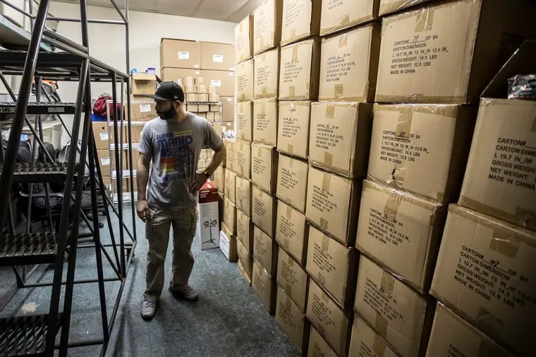 Brian Freifelder, of Philadelphia Media Exchange, looks through his inventory at his business in Bensalem, Pa., where he is a third party seller to Amazon customers. He sells clothing, shoes, mugs and other merchandise on the Amazon Marketplace and other e-commerce platforms, and was hit with a $1.6 million sales tax bill from California. (Michael Bryant/THe PHiladelphia Inquirer/TNS)