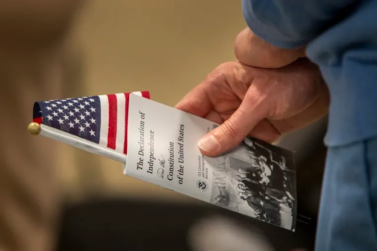 Yuri Melnikov, of Belarus, holds a small U.S. flag and his copy of the Declaration of Independence and the Constitution of the United States during his naturalization ceremony in March.