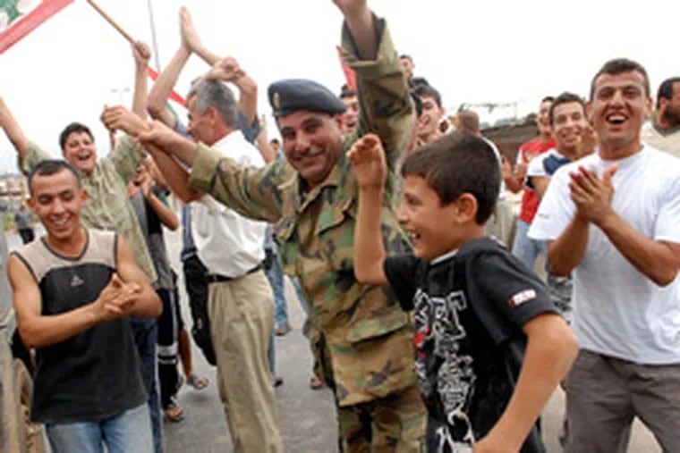 A Lebanese soldier joins the celebration in the streets after the end of the siege at the Nahr el-Bared camp. Residents helped chase down the fleeing militants.