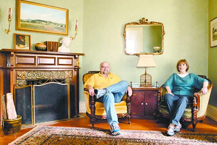 Dean Hartung and Ellen Hutchinson in the living room of their 1889-vintage home in Mount Airy. Found household items and furnishings fill their rooms not only with singular pieces, but with stories of discovery. (Ron Tarver / Staff Photographer)