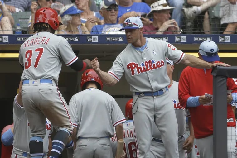 Gabe Kapler congratulates Odubel Herrera after Herrera scored in the seventh inning of the Phillies' 10-9 win over the Brewers on Sunday at Miller Park.