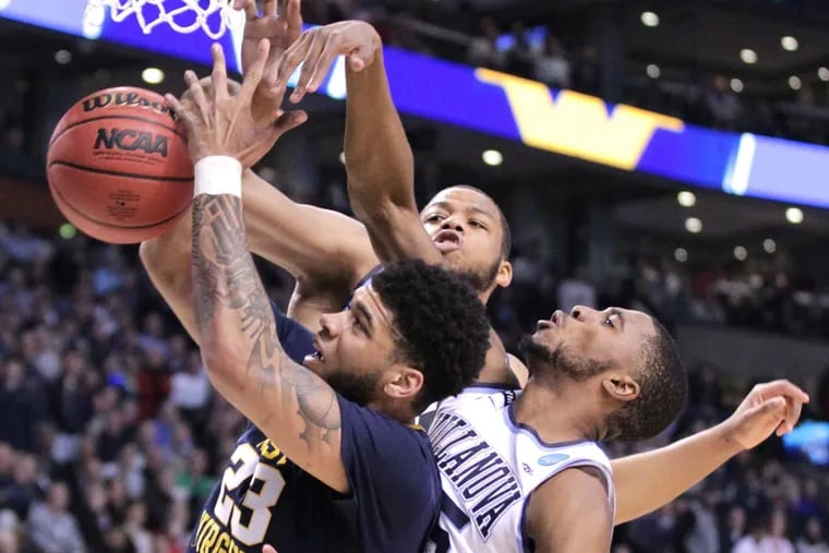 Omari Spellman, center, and Mikal Brigdges, right. of Villanova battle for a rebound with Esa Ahmad of West Virginia during the 2nd half of the East Regionals of the NCAA Tournament at TD Garden on March 23, 2018.