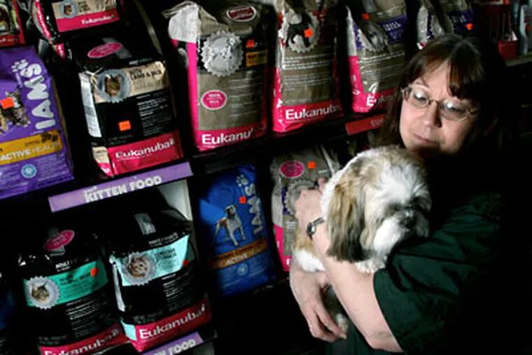 Lydia Grossman with a client, is the owner of Allwood Pet Center in Clifton, New Jersey. Pet stores have seen multiple large increases in dog and cat food prices from manufacturers this past year. (Elizabeth Lara/The Record/MCT)