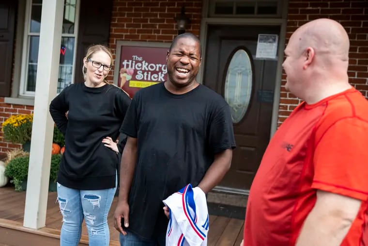 Laura Devlin (left), John Gaskin (center) and Tom Devlin share a laugh outside the Hickory Stick ice cream shop in Perkasie, Pa.  The Devlins befriended Gaskin, helped him get a job, and introduced him to many new friends in the community.
