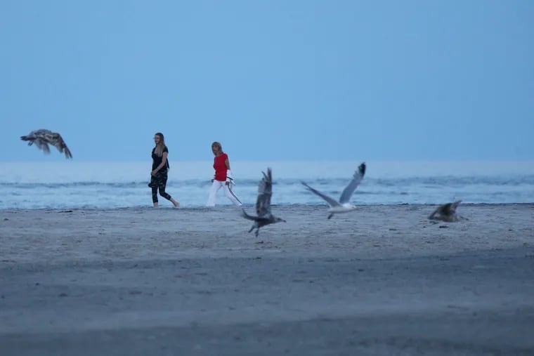 Women walk on the beach at the northern end of Strathmere, N.J., in June.