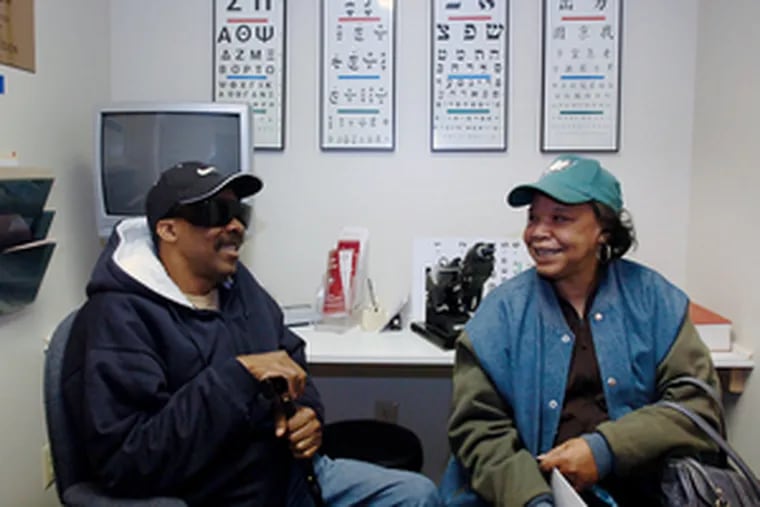 Tom Hughes of Pennsauken waits for an exam with Lonnie Blair, who gave him a ride to the Camden Eye Center. The nonprofit treats mostly low- to moderate-income patients.