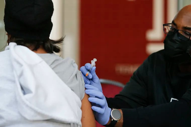 A resident receives their second dose of the COVID-19 vaccine from nurse Michael Hardy during a March 22 Black Doctors COVID-19 Consortium vaccine drive at the Liacouras Center in North Philadelphia.