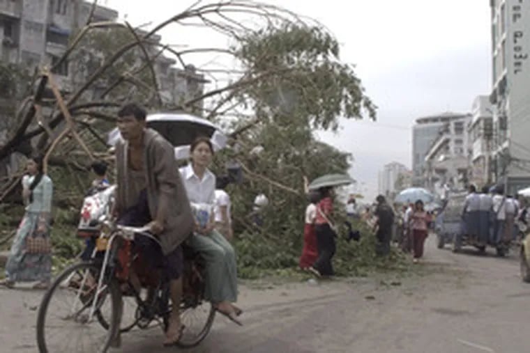 A bicycle taxi driver moves through a damaged area of Yangon. When the British built the city more than a century ago, they lined boulevards with stately trees and created leafy suburbs of lakes and gardens.