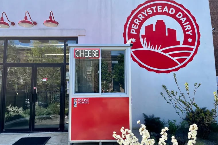 Two neon signs mark the cheese vending machine, housed in a bright-red security booth.