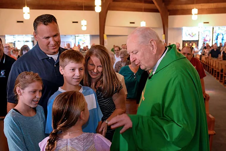 Pastor Fr. Joe Garvin (right) greets the Bowes family at Saint Christopher Parish after they learned they had been chosen to greet Pope Francis when he arrives at the airport in Philadelphia. Richard and Bernadette Bowes are with children Riley (left), 11; Matthew (center), 12; and Gabrielle (back to camera), 9. (TOM GRALISH / Staff Photographer)