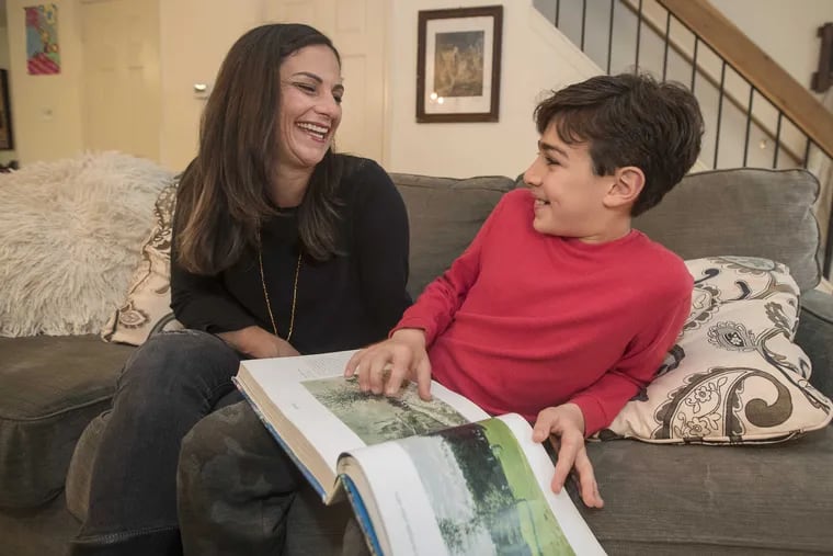 Erica Daniels shares a funny moment with her 12-year-old son, Leo, as they look through a book about Monet, Leo&#039;s favorite artist.