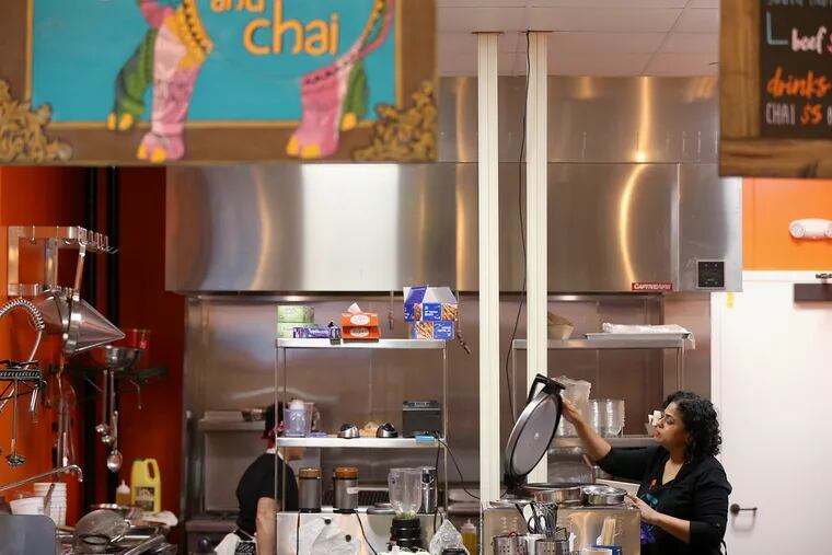 Chaat and Chai chef and owner Anney Thomas works in the kitchen at her restaurant in the Bourse Food Hall. With all the federal buildings near the Bourse, her business has slowed since the government shutdown.
