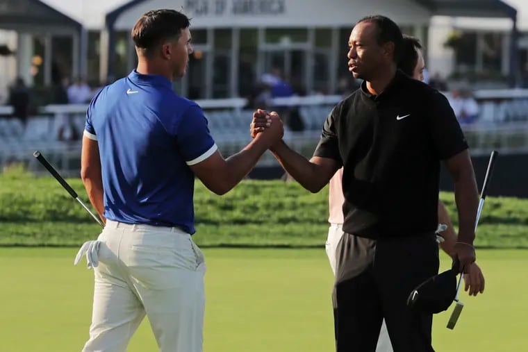 Brooks Koepka, left, shakes hands with Tiger Woods after finishing the second round of the PGA Championship golf tournament, Friday, May 17, 2019, at Bethpage Black in Farmingdale, N.Y.