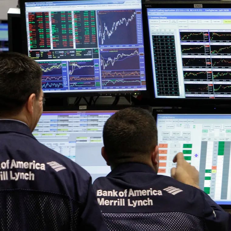 A pair of Bank of America-Merrill Lynch specialists work at their post on the floor of the New York Stock Exchange in 2011.