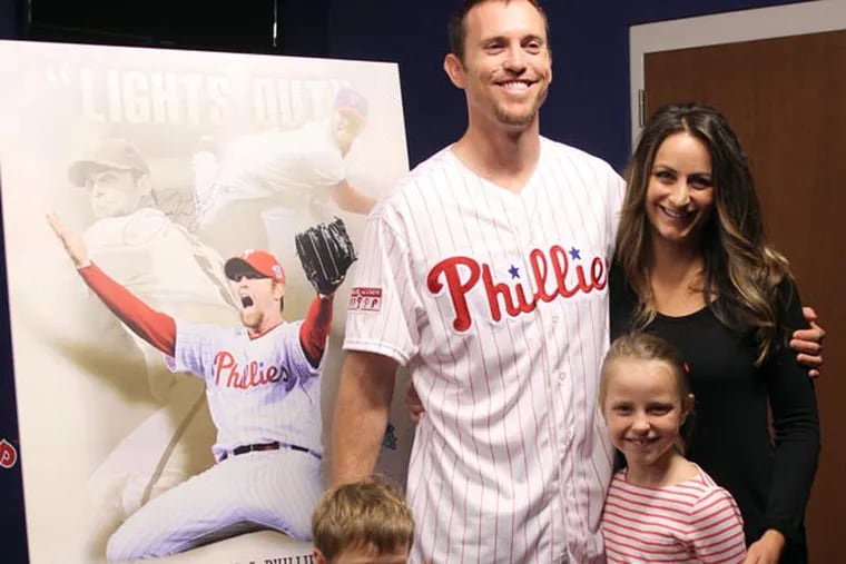 Former Phillies pitcher Brad Lidge stands next to a poster with his
images with his wife Lindsay, daughter Avery and son, Rowan after
Lidge announced his retirement as a member of the Phillies. (Yong Kim/Staff Photographer)