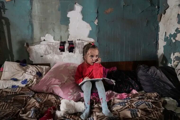 A girl sits in an improvised bomb shelter in Mariupol, Ukraine, Monday, March 7, 2022.