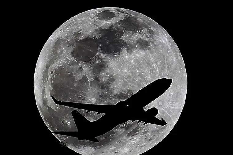 An airliner crosses the moon's path, Monday, April 14, 2014, above Whittier, Calif., approximately one hour before a total lunar eclipse. Then, on April 29, the Southern Hemisphere will be treated to a rare type of solar eclipse. In all, four eclipses will occur this year, two lunar and two solar. (AP Photo/Nick Ut)