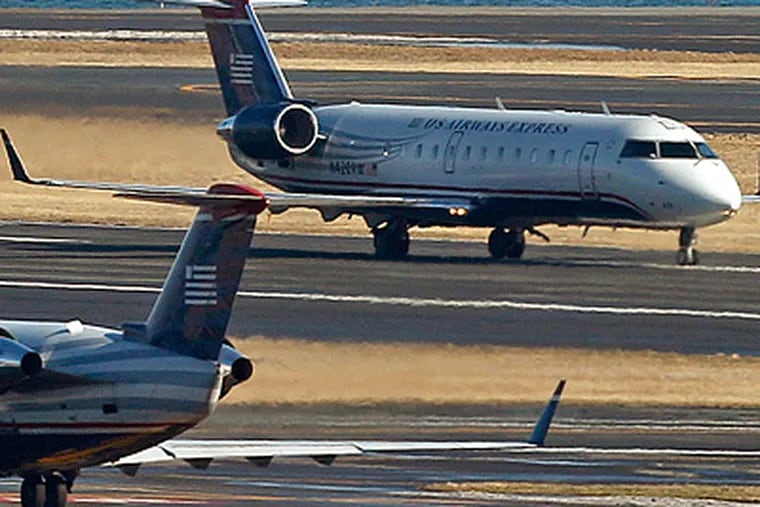 US Airways planes on taxiways at Boston's Logan Airport. &quot;We're busy on every end,&quot; a travel agent said. (Charles Krupa / Associated Press)