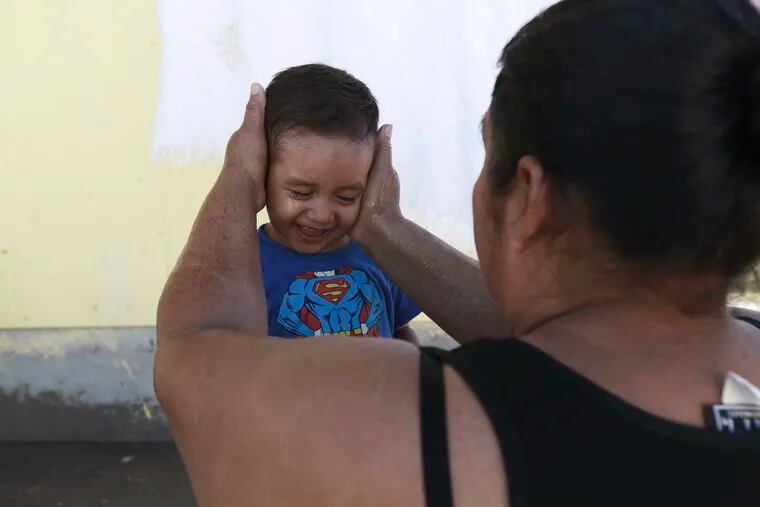 A migrant mother washes her son's face at the Pan de Vida shelter where they are living in Ciudad Juarez, Mexico, while waiting for a chance to request asylum in the United States, Thursday, Sept. 12, 2019. (AP Photo/Christian Chavez)