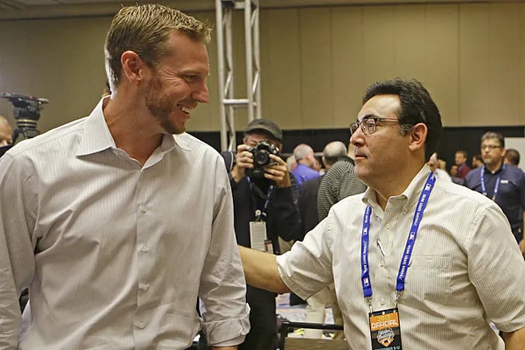 Former Phillies ace Roy Halladay talks with Phillies general manager Ruben Amaro Jr. at Halladay's retirement press conference. (John Raoux/AP)