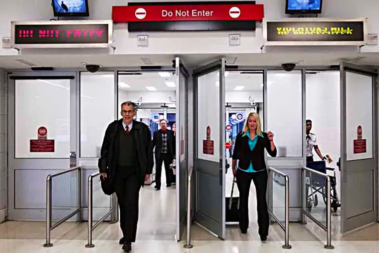 Travelers walk through unmanned security exits between Terminal D & E, Philadelphia International, December 5, 2013.  ( DAVID M WARREN / Staff Photographer )