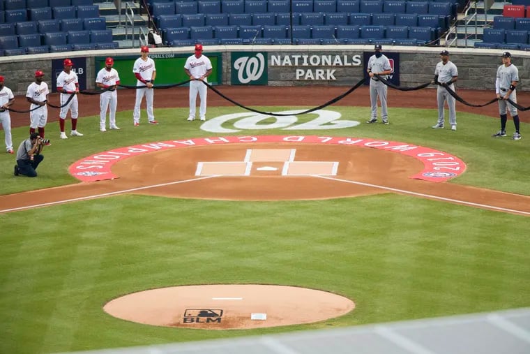 The New York Yankees and the Washington Nationals hold a black ribbon to honor Black Lives Matter before playing an opening day baseball game at Nationals Park.