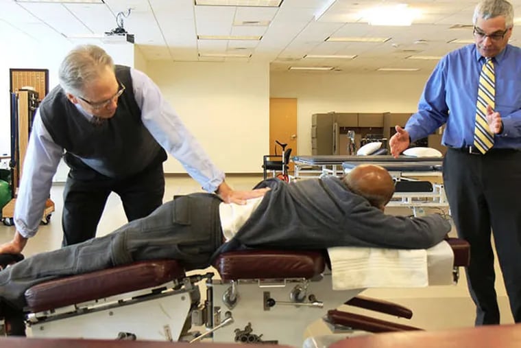 Chiropractor William Telleen (left) works with patient Charles Carter (center), who chats with Tony Delitto, chairman of the University of Pittsburgh's physical therapy department.