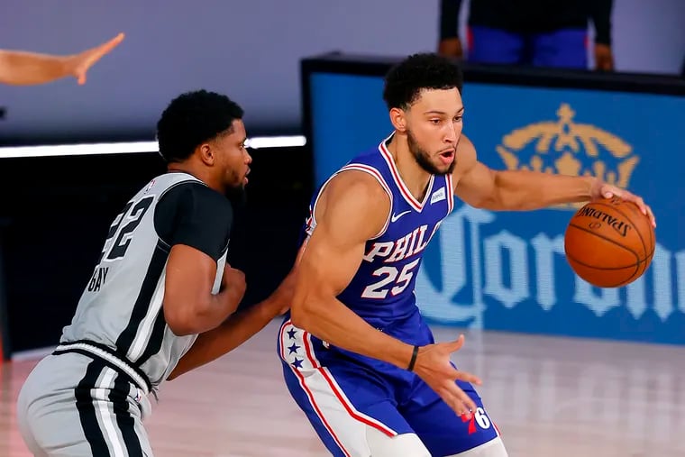 Sixers Ben Simmons (25) is defended by San Antonio Spurs Rudy Gay (22) during the first half of an NBA basketball game Monday,