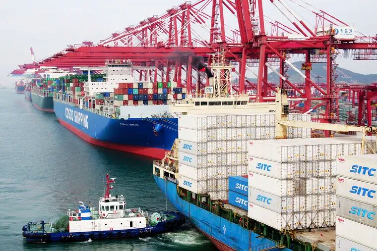In this Wednesday, May 8, 2019, photo, a barge pushes a container ship to the dockyard in Qingdao in eastern China's Shandong province.