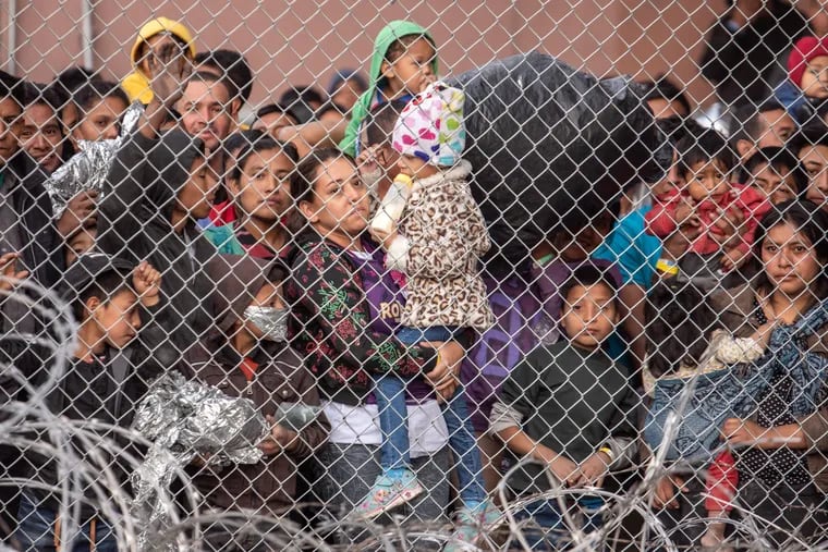 Migrants are gathered inside the fence of a makeshift detention center in El Paso in 2019.