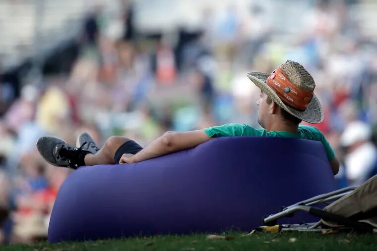 Quinn Meadowcroft relaxes on his inflatable air couch, closing out 3 days of music at the XPoNential Music Festival at Camden’s Wiggins Park on July 28, 2019.