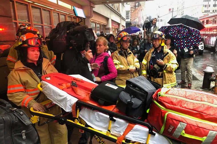 Firefighters prepare to bring a stretcher into a building, Monday, June 10, 2019, in New York, where a helicopter was reported to have crash landed on top of a building in midtown Manhattan. (AP Photo/Mark Lennihan)