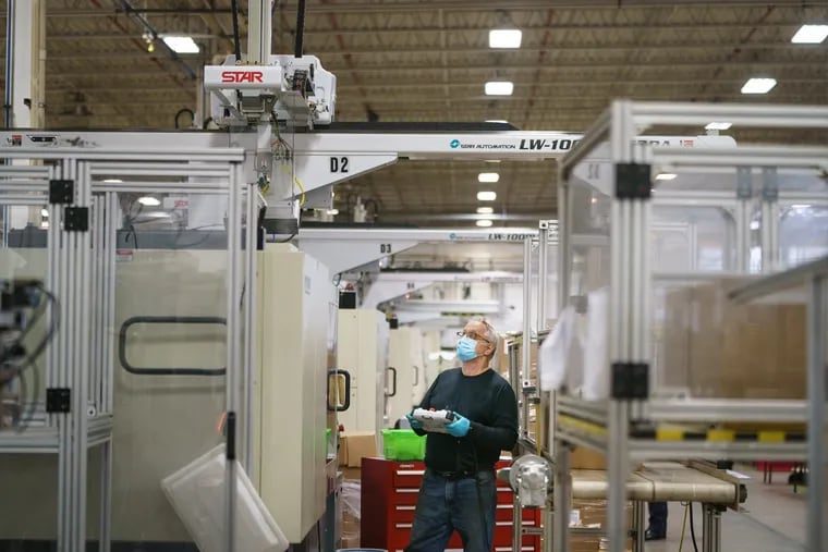 Jerzy Figura, a set up technician at the Rodon Group in Hatfield, monitors the operation of one of Rodon's automated plastic injection molding machines. The company reshored manufacturing of its K'nex toy line from Asia about a decade ago, and now promotes other manufacturers to bring back their overseas production to America.