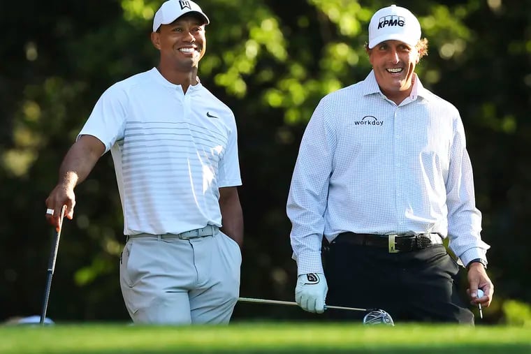 Tiger Woods, left, and Phil Mickelson share a laugh on the 11th tee box while playing a practice round before the 2018 Masters. Will they be this chummy this week as Mickelson returns to the Masters for the first time since joining LIV Golf?