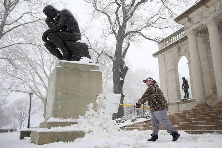Katie Rumsey shovels snow next to The Thinker statue after the March nor'easter. Forecaster thinking we might see more of those this winter.