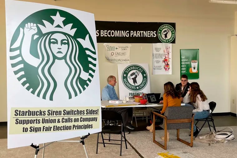 Richard Bensinger (left), who is advising unionization efforts, along with baristas Casey Moore (right), Brian Murray (second from left), and Jaz Brisack (second from right), discuss their efforts to unionize three Buffalo-area stores, inside the movement's headquarters on Oct. 28, 2021 in Buffalo, N.Y. The National Labor Relations Board is scheduled to count ballots Thursday, Dec. 9, 2021, from union elections held at three separate Starbucks stores in the Buffalo area. Two Philadelphia stores took a key step in forming a union last Friday. (AP Photo/Carolyn Thompson, File)
