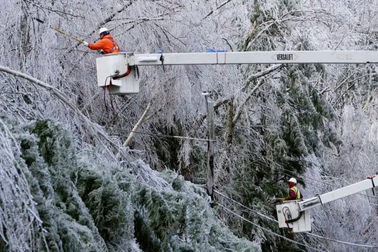 Lamont Priest (left) and Raheem Jefferson of Lewis Tree Service, in Bethlehem, Conn., cut iced tree limbs to get to powerlines in Temple, N.H. They worked yesterday as temperatures got as low as single digits in New Hampshire and Maine.