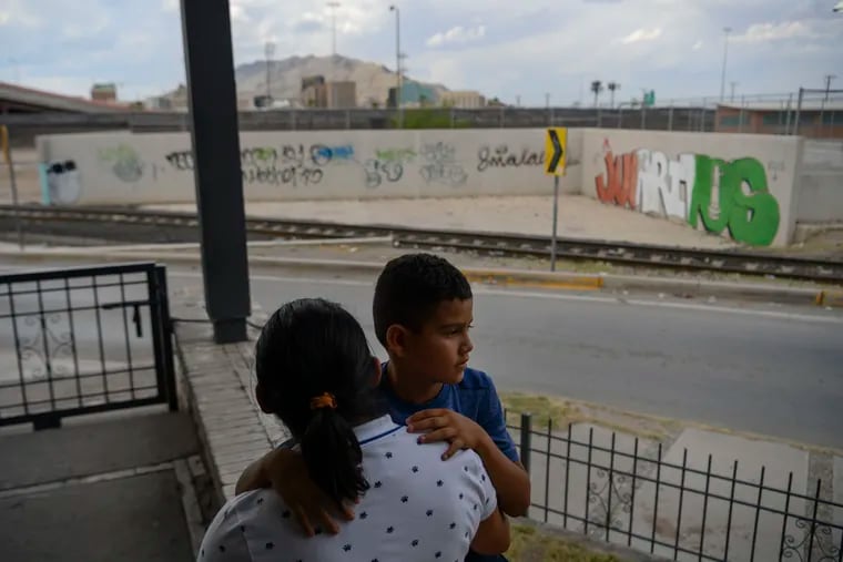 Ana Rojas and her son, Ricardo Rojas, look at the border wall and El Paso on the other side, on June 13. Earlier in the day, they were returned to Ciudad Juarez, Mexico to wait for their asylum hearing in the United States.
